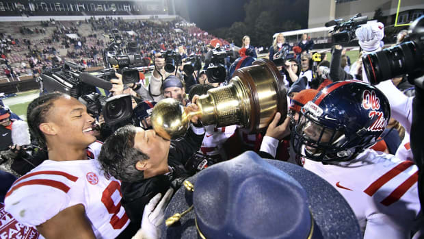 Mississippi Rebels head coach Matt Luke kisses the Egg Bowl trophy after the game against the Mississippi State Bulldogs at Davis Wade Stadium. Mandatory Credit: Matt Bush-USA TODAY Sports